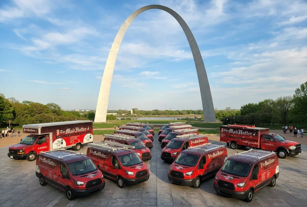 The Mad Hatter fleet of red service vans and trucks lined up beneath the Gateway Arch in St. Louis